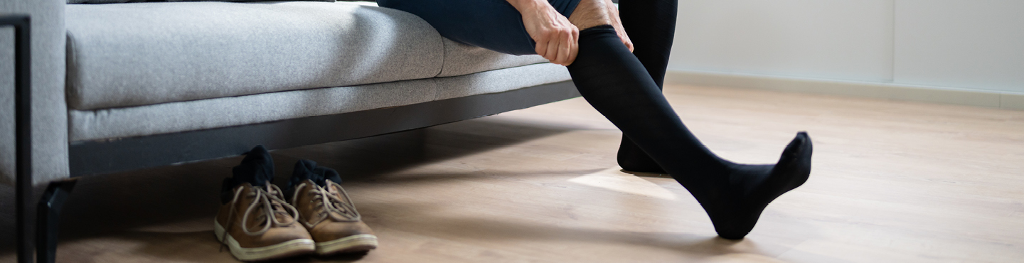 A person putting on their compression socks.